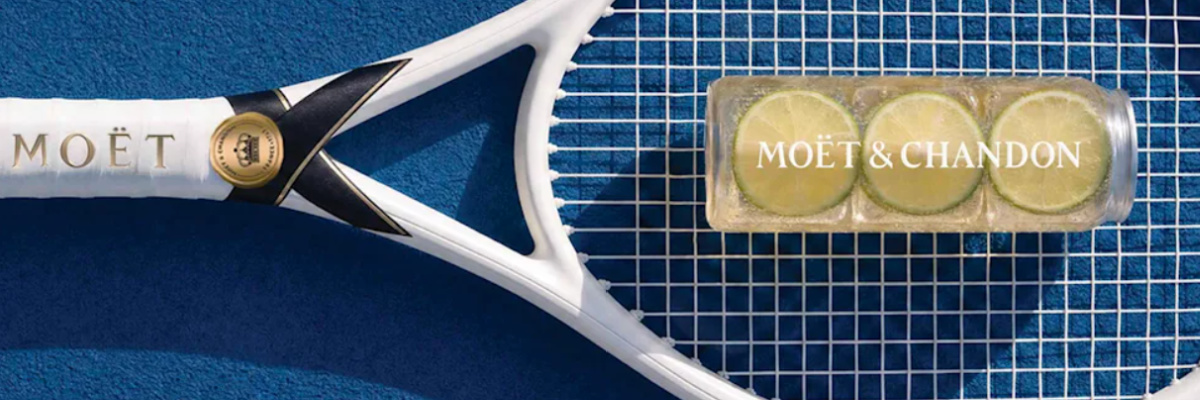 Moët Serve in a clear PET can with lime, resting on a tennis racket at the US Open